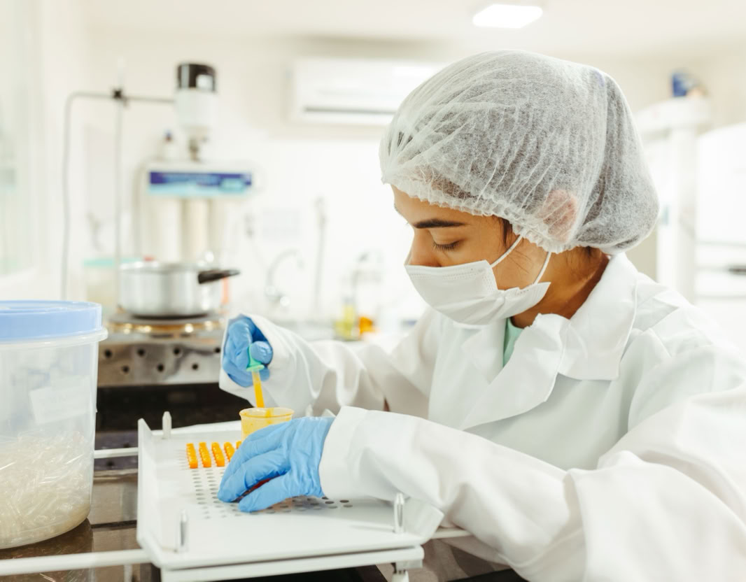 A scientist wearing protective gear performs a meticulous experiment in a laboratory setting.
